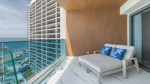 A balcony with a view of a hotel building and a beach. - Encantame Soleil (Puerto Peñasco)