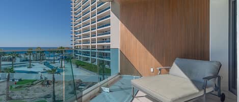A balcony with a view of a swimming pool and a hotel building.