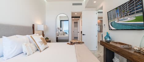 Una habitación de hotel moderna con una cama grande, un espejo, un cuadro de una piscina y vista al área de la piscina.
