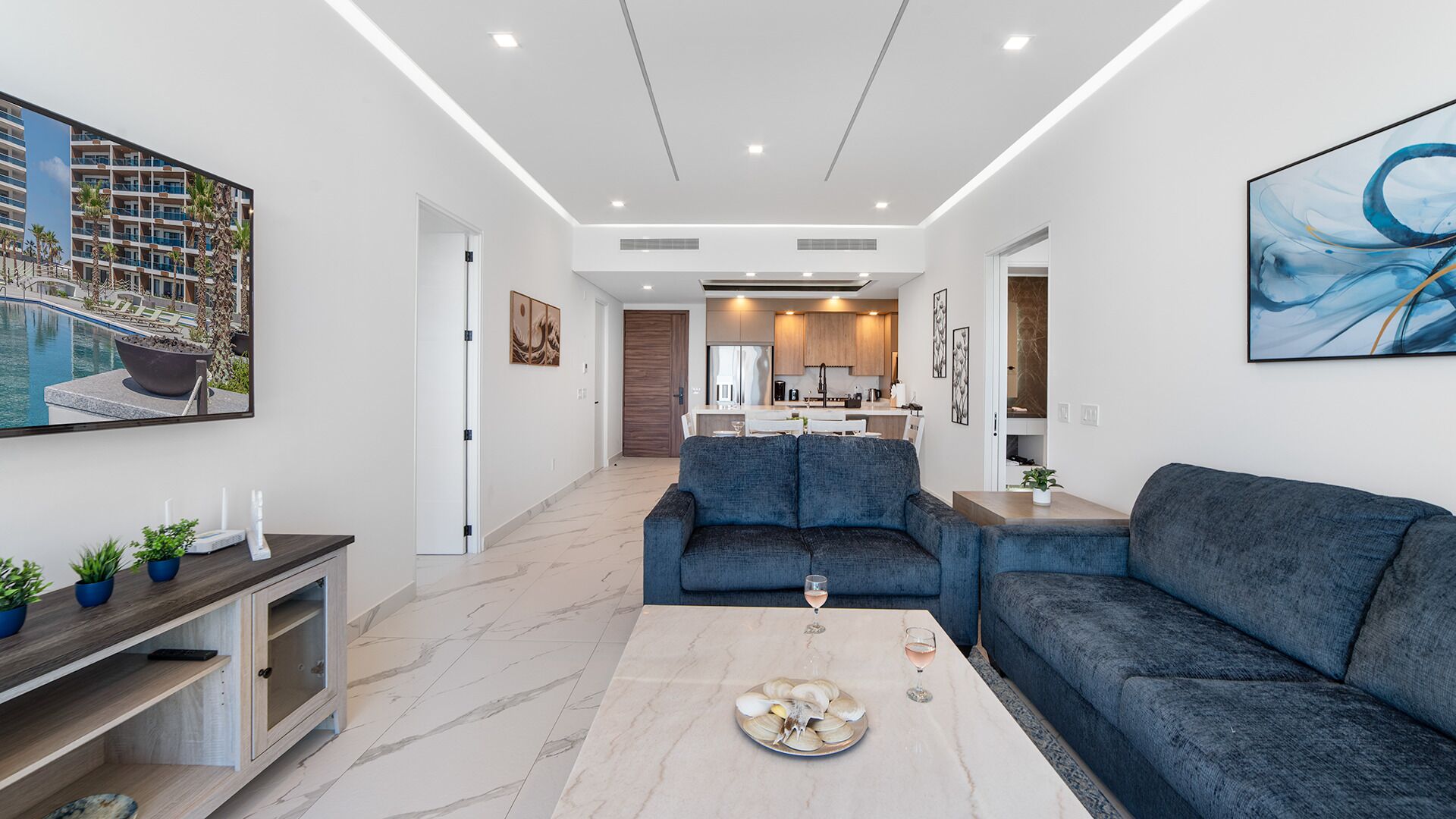 A modern living room with a sofa, coffee table, and artwork.
