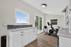 A modern kitchen with white cabinetry, a black tiled backsplash, and a large window offering a view of the outdoors. - Modern Stunner Walkable to Lake Travis + Views! (Austin)