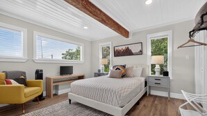 A modern bedroom with a bed, a desk, a chair, and a TV. - Modern Stunner Walkable to Lake Travis + Views! (Austin)