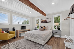 A modern bedroom with a bed, a desk, a chair, and a TV. - Modern Stunner Walkable to Lake Travis + Views! (Austin)
