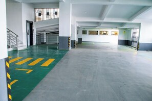 Eine mehrgeschossige Parkgarage mit einem grünen Pfeil auf dem Boden.