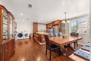 A spacious kitchen with wooden cabinets, a central island, and a dining area with a wooden table and chairs. - Beautiful 4-bedroom home, Comfortable, stylish and spacious (Baldwin Park)