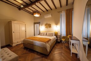 Ein Schlafzimmer mit Bett, Schreibtisch, Stuhl, Kleiderschrank und einer dekorativen Wandgestaltung.