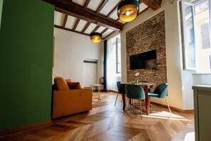 Ein modernes Wohnzimmer mit einer Couch, einem Esstisch, Stühlen und einem Kamin.
