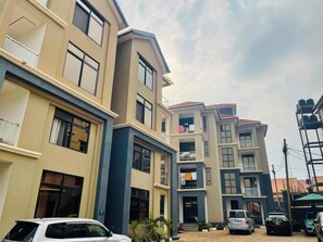 Ein mehrstöckiges Wohnhaus mit Balkonen und einem Parkplatz.
