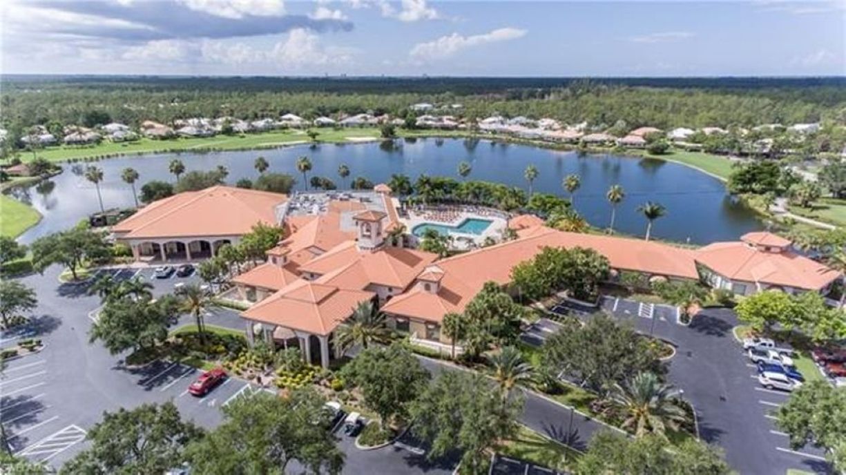 A resort with a central building, a swimming pool, and a lake.