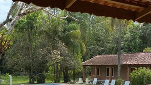 A swimming pool with lounge chairs, a covered patio, and a brick building in the background. - in Jarinu with 4 bathrooms (Jarinu)