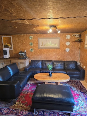 A living room with a sectional sofa, a coffee table, and a patterned rug. - Mountain Retreat Maslo (Babino Polje)