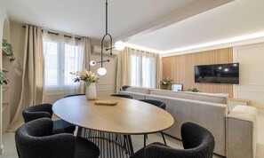 A modern living room with a round table, sofas, a flat-screen TV, and a fireplace. - TASTEFULLY DECORATED WITH MODERN ELEGANCE, STEPS FROM LA CROISETTE & BEACHES. (Cannes)