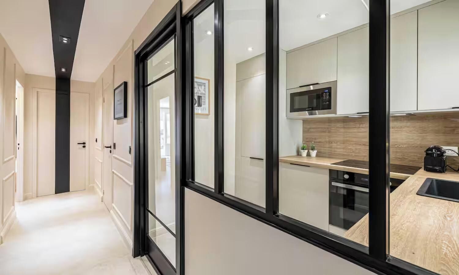 A modern kitchen with a microwave, stove, and wooden countertop.