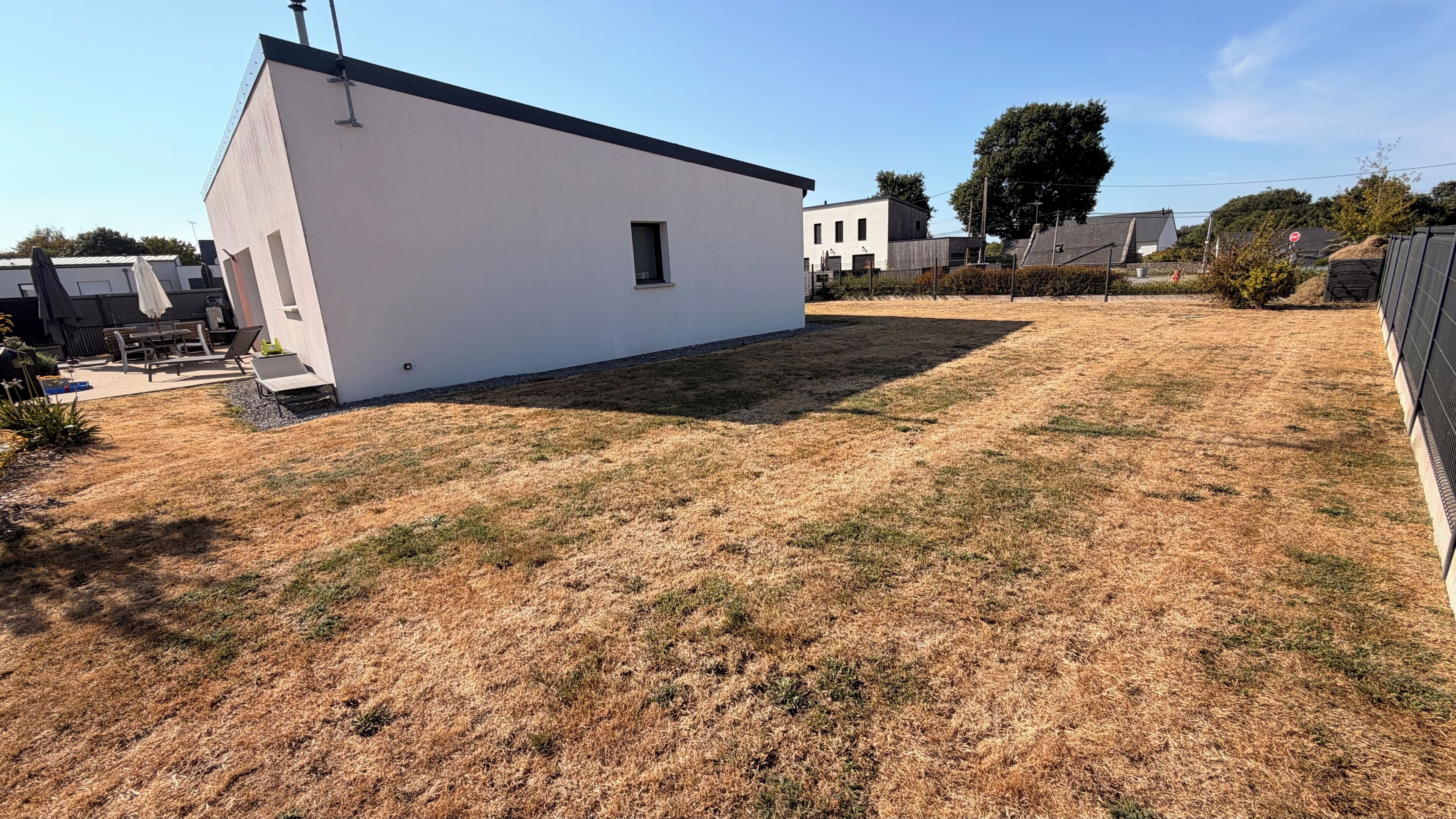 A white building with a flat roof, a small window, and a door.