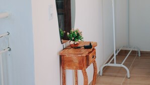 A room with a wooden bench, a mirror, and a potted plant. - A cozy, spacious home for families and couples (sleeps 6), just 5 minutes from the beach (Lagoinha Paraipaba)