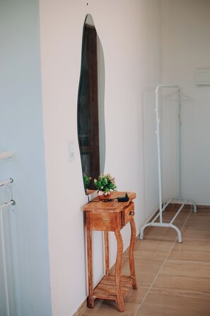 A room with a wooden bench, a mirror, and a potted plant. - A cozy, spacious home for families and couples (sleeps 6), just 5 minutes from the beach (Lagoinha Paraipaba)
