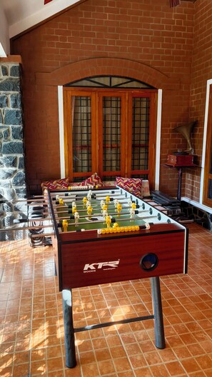 A foosball table in a room with brick walls and a stone accent wall.