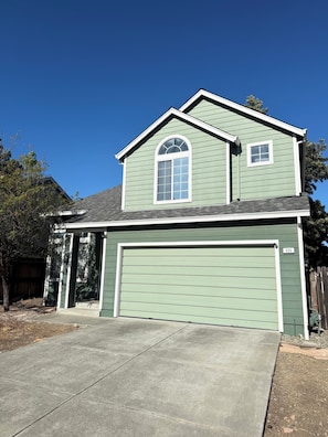 A two-story house with a garage, a front porch, and a small window on the upper floor. - Spacious Home Near Napa Valley & Six Flags in Suisun City (Suisun City)