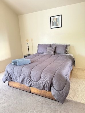 A bedroom with a bed, a nightstand, a lamp, and a framed picture on the wall. - Spacious Home Near Napa Valley & Six Flags in Suisun City (Suisun City)