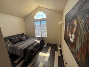 A bedroom with a bed, a window, a painting, and a floor lamp. - Spacious Home Near Napa Valley & Six Flags in Suisun City (Suisun City)