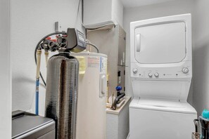 A compact room with a water heater, a washing machine, and a small sink. - Sunrise Siesta on Lake LBJ! (Sunrise Beach Village)