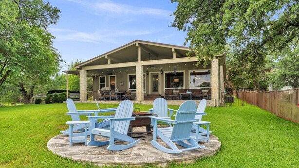 A covered outdoor seating area with a table and chairs, surrounded by a well-maintained lawn. - Sunrise Siesta on Lake LBJ! (Sunrise Beach Village)