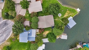 An aerial view of a residential area with houses, a dock, and a body of water. - Sunrise Siesta on Lake LBJ! (Sunrise Beach Village)