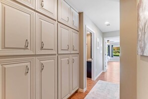 A hallway with a series of cabinets and a view into a room with a window. - Waterfront Escape: Long Mountain Drive Lakehouse! (Llano County)