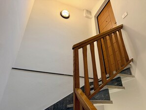 Eine Holztreppe mit Geländer, die zu einer Zwischenebene führt.