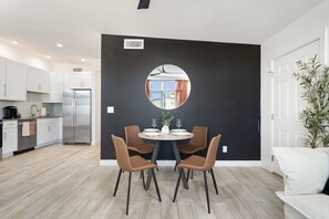 A modern kitchen with white cabinets, a stainless steel refrigerator, and a dining area with a round table and four chairs. - 2BR Scottsdale Ranch Retreat w/ Patio & BBQ (Scottsdale)