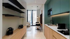 A modern kitchen with built-in appliances, a dining area with a view, and a kitchenette. - Relaxed Studio in Upside w/ Burj View (Dubai)