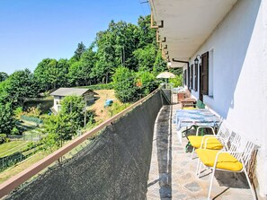 Un balcone con vista su un giardino e un edificio.