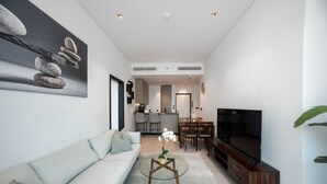 Ein modernes Wohnzimmer mit einer Couch, einem Couchtisch und einem Flachbildfernseher.