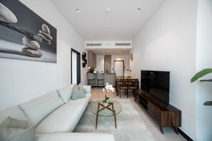 Ein modernes Wohnzimmer mit einer Couch, einem Couchtisch und einem Flachbildfernseher.