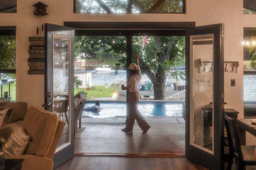 Um espaço interno com uma porta de vidro que dá para uma área de piscina externa.