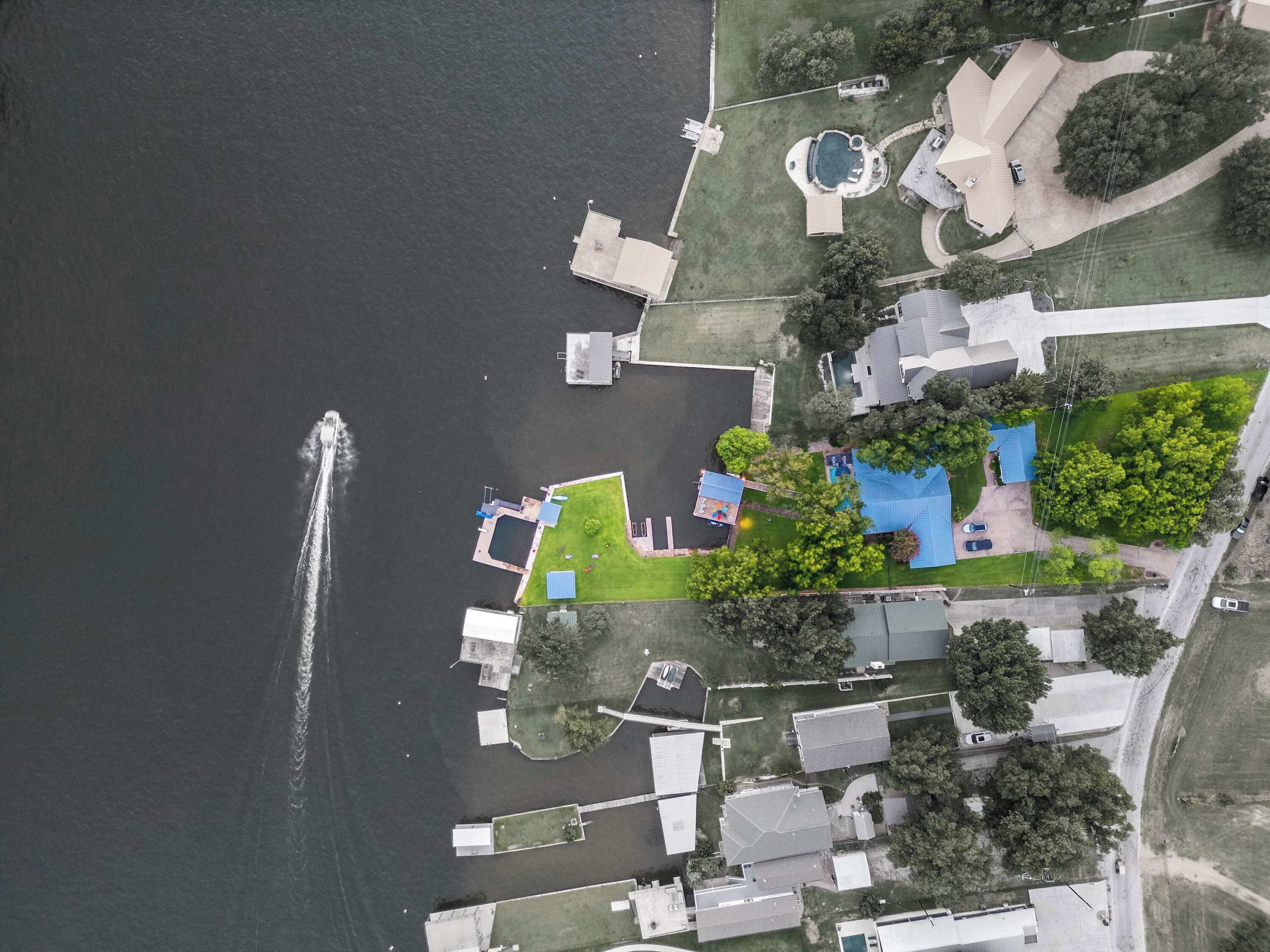 Oversigtsbillede af et boligområde med en bro, swimmingpool og forskellige bygninger.