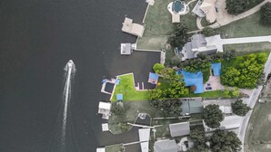 An aerial view of a residential area with a dock, swimming pool, and various buildings. - Lakeshore Retreat | Pool, Spa & Private Peninsula (Kingsland)