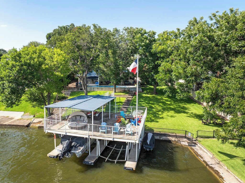 Un barco amarrado con zona de estar techada y una bandera.