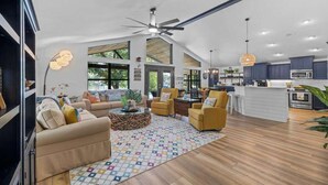 A spacious living area with a sofa, armchairs, a coffee table, and a patterned rug. - Lakeshore Retreat | Pool, Spa & Private Peninsula (Kingsland)
