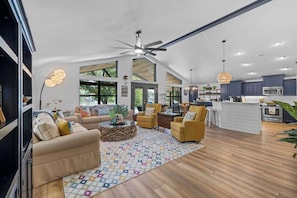 A spacious living area with a sofa, armchairs, a coffee table, and a patterned rug. - Lakeshore Retreat | Pool, Spa & Private Peninsula (Kingsland)