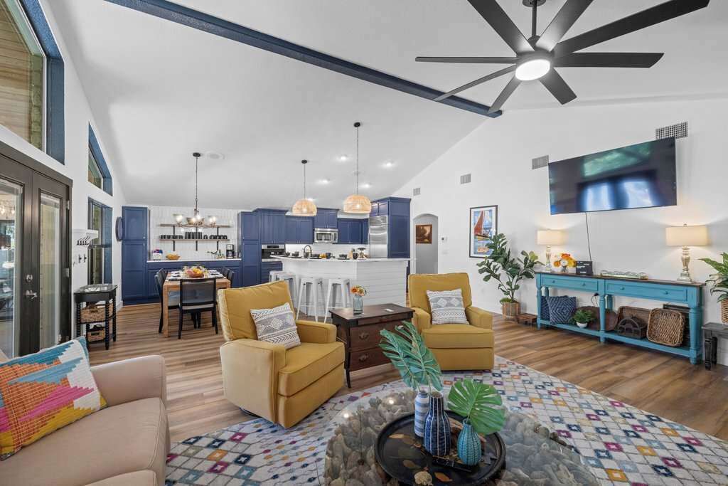 A spacious living area with a high ceiling, a dining area, and a kitchen.