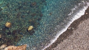 A beach with clear water, pebbles, and a rocky outcrop. - TenoHomes Atlantic View Icod Terrace (San Marcos)