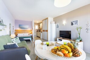 En moderne stue med spiseområde, køkken og soveværelse.