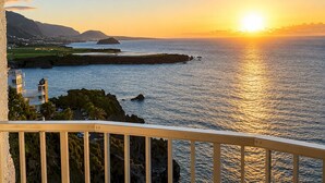 A coastal sunset view from a balcony with a railing, overlooking the sea and distant land. - TenoHomes Atlantic View Icod Terrace (San Marcos)