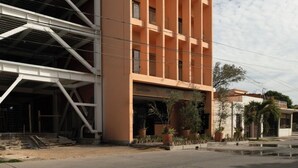 A multi-story building with a prominent 'Macer' sign, featuring a modern architectural design with balconies and a flat roof. - The coolest spot to experience the city. (Mazatlán)