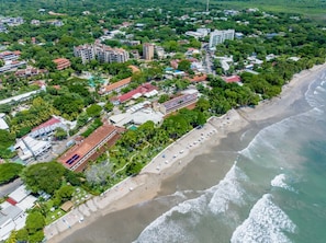 Eine Luftaufnahme einer Küstenregion mit Gebäuden, einem Strand und einer Strandpromenade.