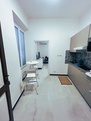 A compact kitchen with a dining area, a microwave, and a small refrigerator. - Casa Marietta - Studio Apartment, Sleeps 2 (Arenzano)