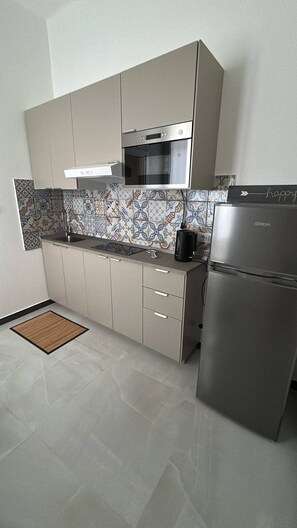 Eine moderne Küche mit Backofen, Kühlschrank und Kaffeemaschine.