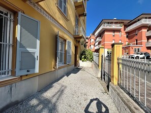 Eine enge Straße mit Gebäuden an beiden Seiten, mit Balkonen und einem Kiesweg.