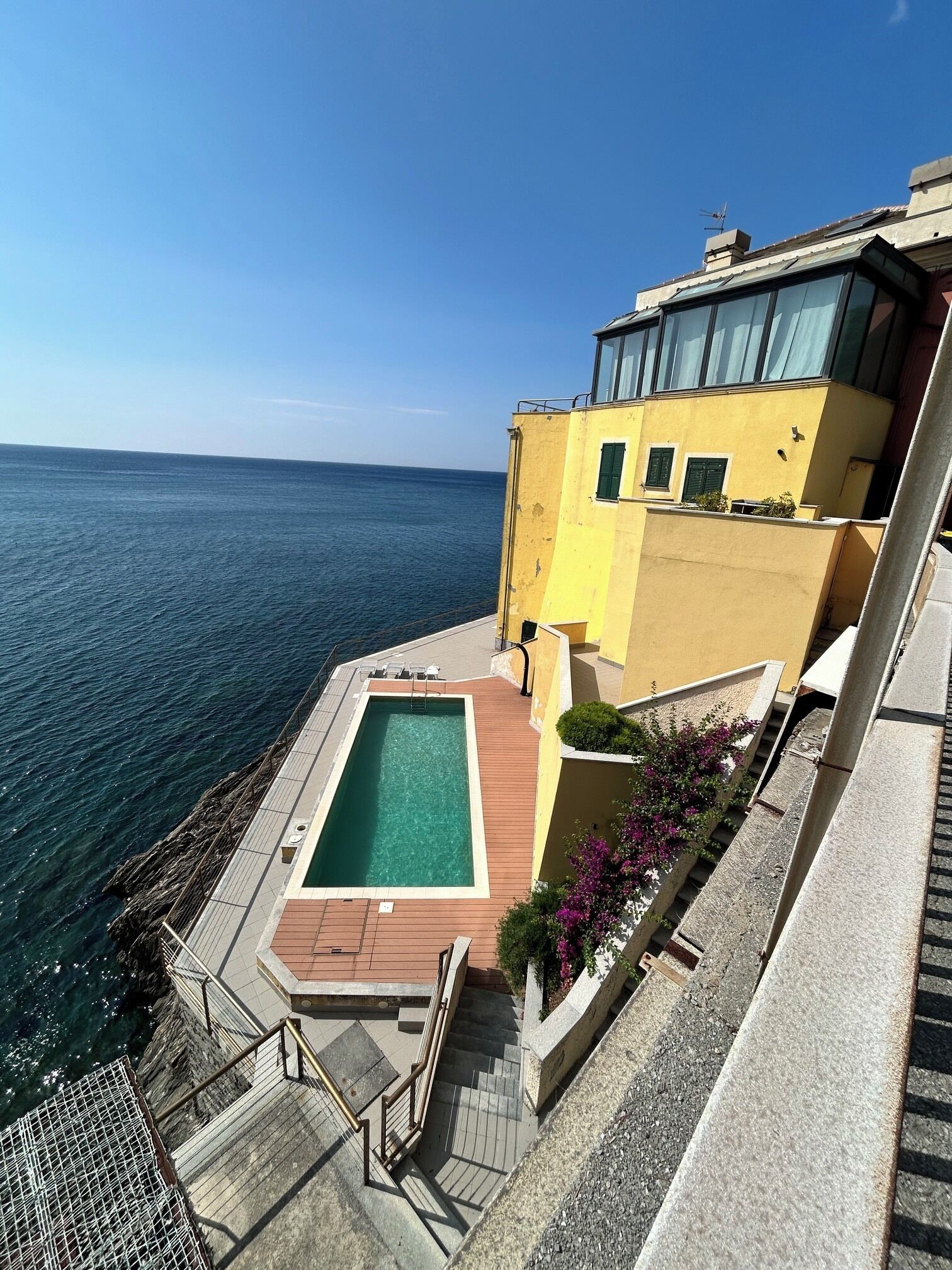 A residential building with a pool and a view of the sea.